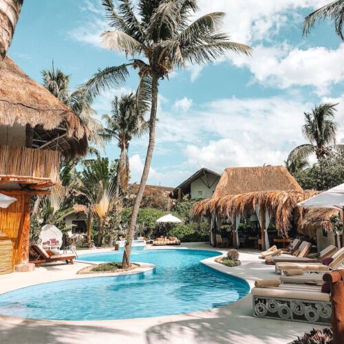 thatch huts and houses by the pool during day
