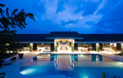 blue body of water in front of building near trees during nighttime