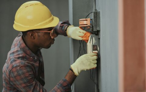 man in brown hat holding black and gray power tool